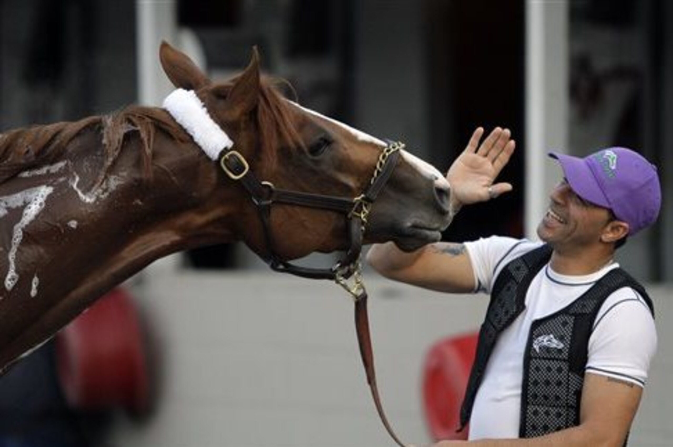 Exercise rider William Delgado plays with Kentucky Derby hopeful California Chrome after a morning workout at Churchill Downs Wednesday, April 30, 2014, in Louisville, Ky. (AP Photo/Garry Jones)