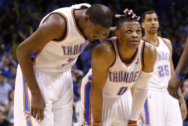 Oklahoma City Thunder forward Kevin Durant (35) pats teammate Russell Westbrook on the head as Westbrook prepares to take a foul shot in the fourth quarter of an NBA basketball game against the Detroit Pistons in Oklahoma City, Wednesday, April 16, 2014. Oklahoma City won 112-111. Guard Thabo Sefolosha (25) is at right. (AP Photo/Sue Ogrocki)