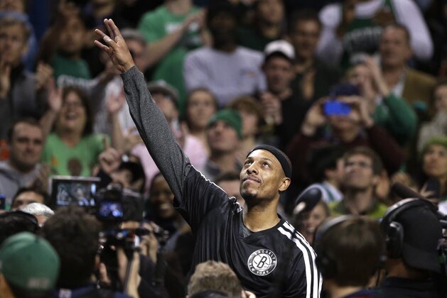 Brooklyn Nets forward Paul Pierce, center, formerly of the Boston Celtics, waves to the crowd during a tribute to him in an NBA basketball game against the Boston Celtics, Sunday, Jan. 26, 2014, in Boston. (AP Photo/Steven Senne)