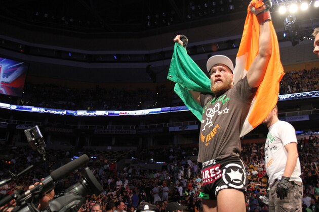 Conor McGregor, of Ireland, leaves the ring draped in an Irish flag after beathing Max Holloway in their UFC on Fox Sports 1 mixed martial arts bout in Boston, Saturday, August 17,2013. McGregor won via unanimous decision. (AP Photo/Gregory Payan)
