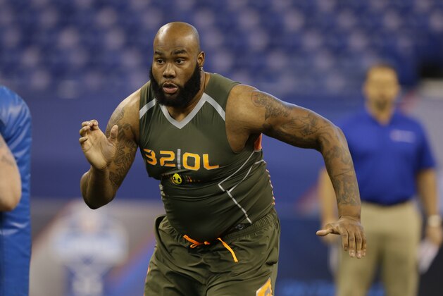 Virginia offensive lineman Morgan Moses runs a drill at the NFL football scouting combine in Indianapolis, Saturday, Feb. 22, 2014. (AP Photo/Michael Conroy)