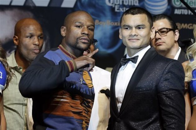 Floyd Mayweather Jr. left, and Marcos Maidana pose for photos during a news conference Wednesday, April 30, 2014, in Las Vegas. The pair square off in a welterweight title fight on Saturday, May 3.  (AP Photo/Isaac Brekken)