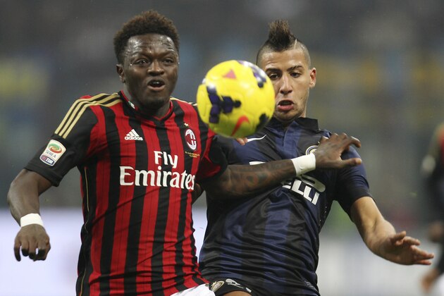 AC Milan midfielder Sulley Muntari, left, of Ghana, challenges for the ball with Inter Milan midfielder Saphir Taider, of Algeria, during the Serie A soccer match between Inter Milan and AC Milan at the San Siro stadium in Milan, Italy, Sunday, Dec. 22, 2013. (AP Photo/Antonio Calanni)