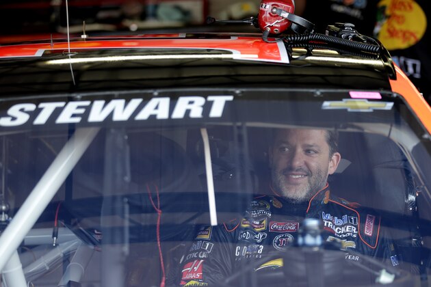 Tony Stewart smiles as he waits in his car during a NASCAR Sprint Cup series auto race practice at Darlington Speedway in Darlington, S.C., Friday, April 11, 2014. (AP Photo/Chuck Burton)