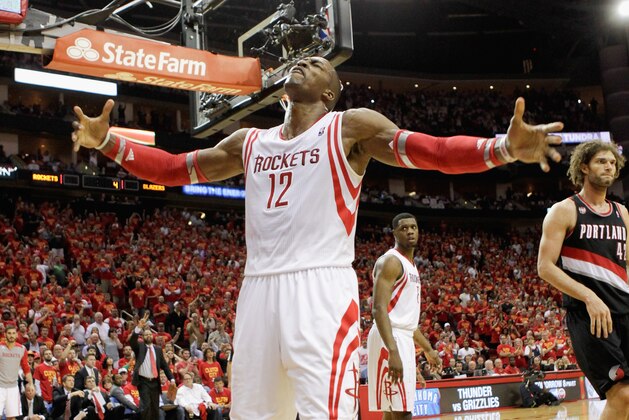 HOUSTON, TX - APRIL 30:  Dwight Howard #12 of the Houston Rockets gets the crowd going after a defensive stop with less than two minutes to go in Game 5 of the Western Conference Quarterfinals during the 2014 NBA Playoffs at the Toyota Center on April 30, 2014 in Houston, Texas. Houston won 108-98. NOTE TO USER: User expressly acknowledges and agrees that, by downloading and or using this photograph, User is consenting to the terms and conditions of the Getty Images License Agreement  (Photo by Bob Levey/Getty Images)