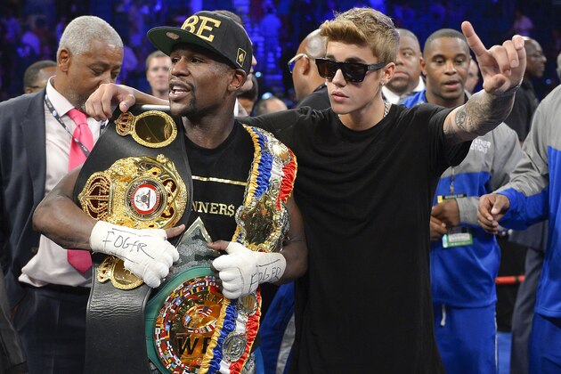 Floyd Mayweather Jr., left, poses for photos with Justin Bieber after defeating Canelo Alvarez during a 152-pound title fight, Saturday, Sept. 14, 2013, in Las Vegas. (AP Photo/Mark J. Terrill)