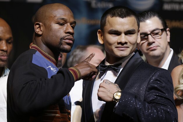 Floyd Mayweather Jr., left, and Marcos Maidana pose for photos during a news conference Wednesday, April 30, 2014, in Las Vegas. The pair square off in a welterweight title fight on Saturday, May 3.  (AP Photo/Isaac Brekken)