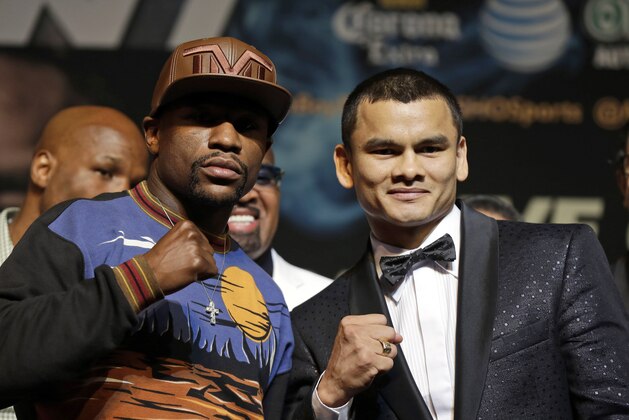 Floyd Mayweather Jr., left, and Marcos Maidana pose for photos during a news conference Wednesday, April 30, 2014, in Las Vegas. The pair square off in a welterweight title fight on Saturday, May 3.  (AP Photo/Isaac Brekken)