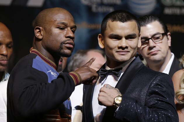 Floyd Mayweather Jr., left, and Marcos Maidana pose for photos during a news conference Wednesday, April 30, 2014, in Las Vegas. The pair square off in a welterweight title fight on Saturday, May 3.  (AP Photo/Isaac Brekken)