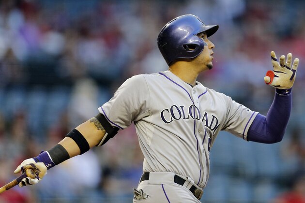 Colorado Rockies' Carlos Gonzalez watches his two run home run take flight against the  Arizona Diamondbacks during the first inning of a baseball game on Wednesday, April 30, 2014, in Phoenix. (AP Photo/Matt York)