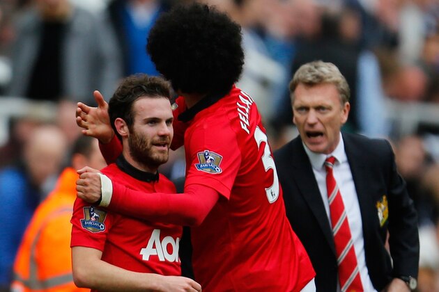 NEWCASTLE UPON TYNE, ENGLAND - APRIL 05: Juan Mata of Manchester United (L) celebrates with team mate Marouane Fellaini after scoring their first goal while Manager David Moyes (R) of Manchester United reacts during the Barclays Premier League match between Newcastle United and Manchester United at St James' Park on April 5, 2014 in Newcastle upon Tyne, England. (Photo by Paul Thomas/Getty Images)