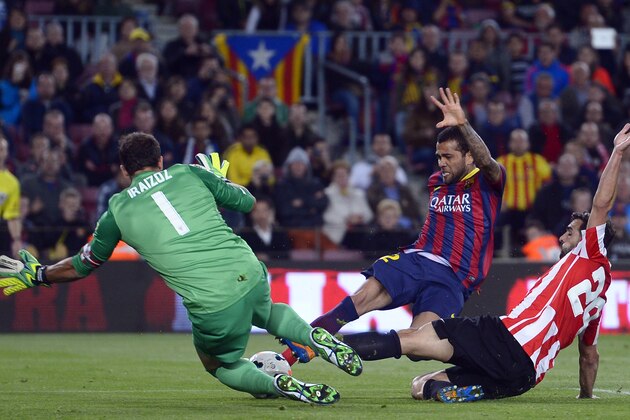 FC Barcelona's Daniel Alves, from Brazil, center, duels for the ball against Athletic Bilbao's goalkeeper Gorka Iraizoz, left, and Mikel Balenziaga, right, during a Spanish La Liga soccer match at the Camp Nou stadium in Barcelona, Spain, Sunday April 20, 2014. (AP Photo/Manu Fernandez)