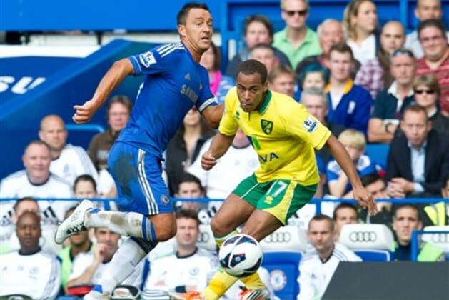 Chelsea's John Terry, left, controls the ball past Norwich City's Elliott Bennett during their English Premier League soccer match at the Stamford Bridge Stadium, London, Saturday, Oct. 6, 2012. (AP Photo/Tom Hevezi)