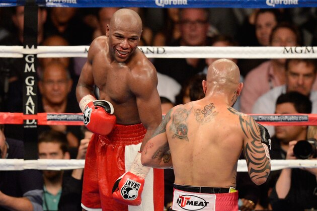 LAS VEGAS, NV - MAY 05:  (L-R) Floyd Mayweather Jr. smiles in the ring against Miguel Cotto during their WBA super welterweight title fight at the MGM Grand Garden Arena on May 5, 2012 in Las Vegas, Nevada.  (Photo by Ethan Miller/Getty Images)