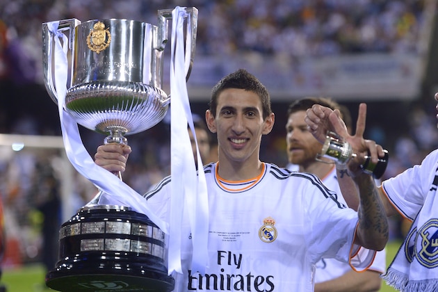 Real's Angel Di Maria poses with the trophy at the end of the final of the Copa del Rey between FC Barcelona and Real Madrid at the Mestalla stadium in Valencia, Spain, Wednesday, April 16, 2014. Real defeated Barcelona 2-1. (AP Photo/Manu Fernandez)