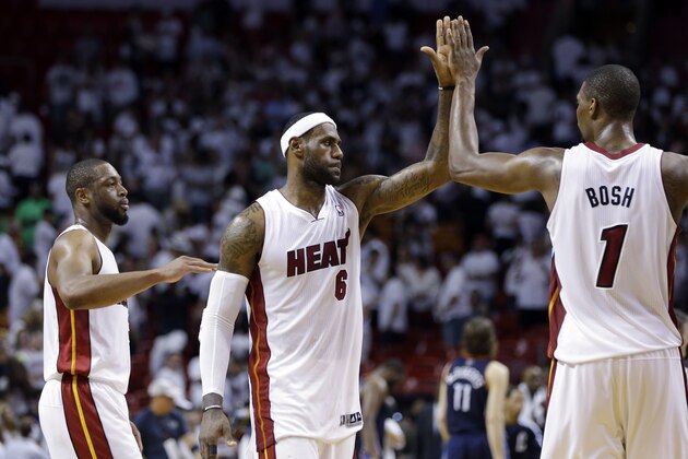 Miami Heat's LeBron James (6) high-fives Chris Bosh (1) after the Heat defeated the Charlotte Bobcats 101-97 in Game 2 of an opening-round NBA basketball playoff series, Wednesday, April 23, 2014, in Miami. At left is Dwyane Wade. (AP Photo/Lynne Sladky)