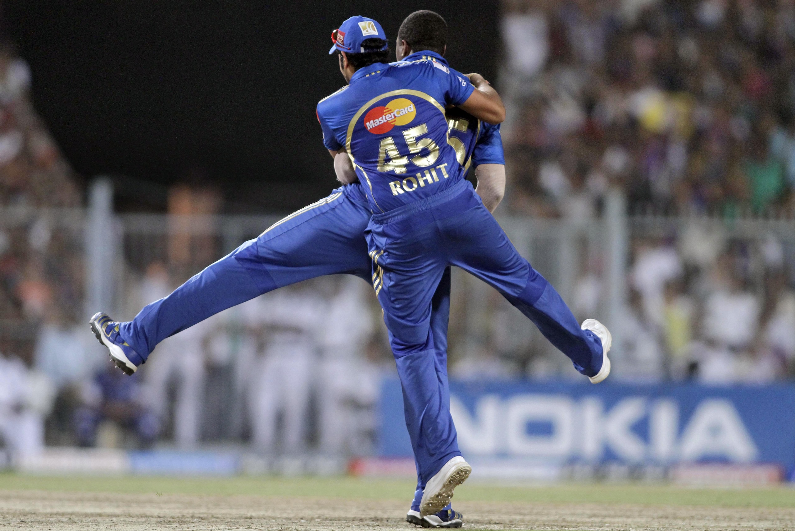 Mumbai Indians' Rohit Sharma celebrates with teammate Kieron Pollard after Pollard dismissed Kolkata Knight Riders' Manoj Tiwary, unseen, during an Indian Premier League (IPL) cricket match in Kolkata, India, Saturday, May 12, 2012. (AP Photo/Bikas Das)