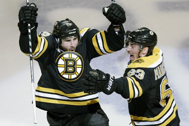 Boston Bruins defenseman Johnny Boychuk, left, raises his arms as he celebrates his tying goal, which forced the game into overtime, against the Montreal Canadiens during the third period of Game 1 in the second-round of the Stanley Cup playoff series in Boston, Thursday, May 1, 2014. At right is center Brad Marchand. (AP Photo/Charles Krupa)