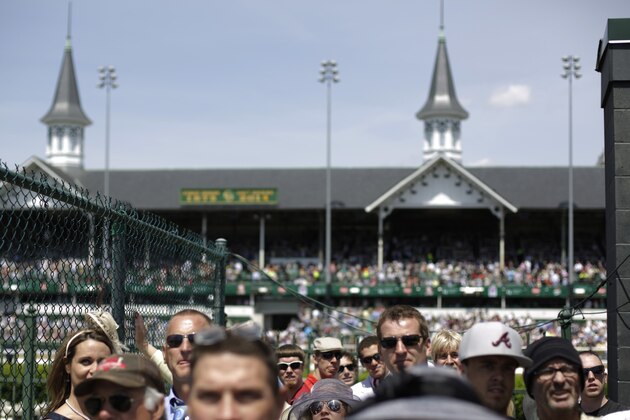 Fans look at a large video board before the 140th running of the Kentucky Derby horse race at Churchill Downs Saturday, May 3, 2014, in Louisville, Ky. (AP Photo/David Goldman)