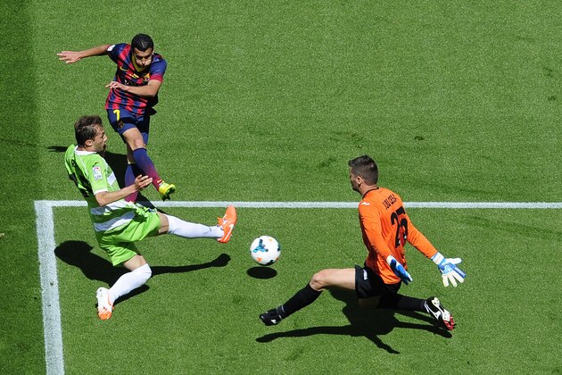 FC Barcelona's Pedro Rodriguez, second left, duels for the ball against Getafe's Rafa Lopez, left, and goalkeeper Julio Cesar, right, during a Spanish La Liga soccer match at the Camp Nou stadium in Barcelona, Spain, Saturday, May 3, 2014. (AP Photo/Manu Fernandez)