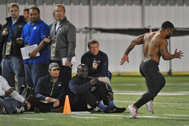Scouts time Georgia Tech NCAA college football running back Robert Godhigh, right,  during his 40 yard sprint on NFL pro day Friday, March 28, 2014, in Atlanta. (AP Photo/David Tulis)