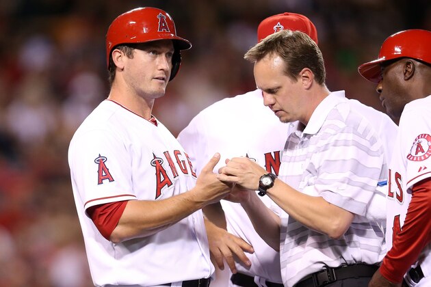 ANAHEIM, CA - MAY 02:  ANAHEIM, CA - MAY 02 : David Freese #6 of the Los Angeles Angels of Anaheim is checked by trainer Adam Nevala after being hit by a pitch in the hand in the third inning against the Texas Rangers at Angel Stadium of Anaheim on May 2, 2014 in Anaheim, California.  Freese later left the game.  (Photo by Stephen Dunn/Getty Images)