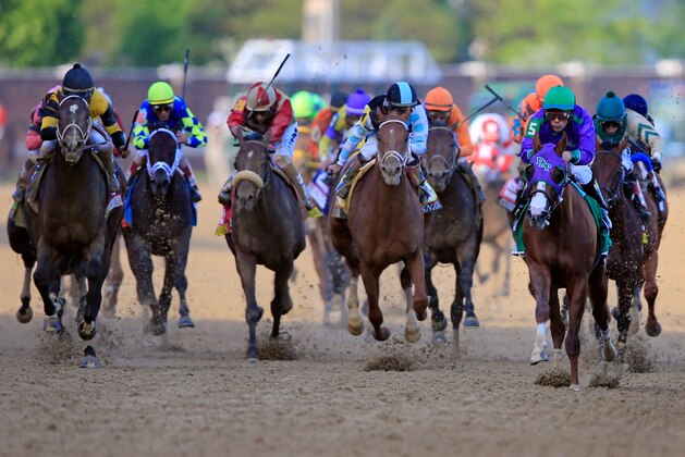 LOUISVILLE, KY - MAY 03:  Jockey Victor Espinoza guides California Chrome #5 to the finish line to win the 140th running of the Kentucky Derby at Churchill Downs on May 3, 2014 in Louisville, Kentucky.  (Photo by Rob Carr/Getty Images)