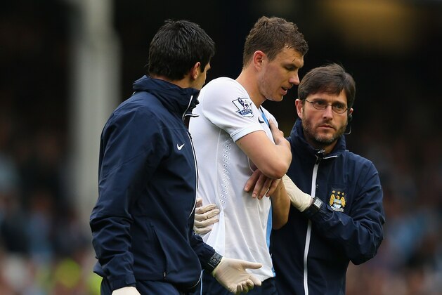 LIVERPOOL, ENGLAND - MAY 03:  Edin Dzeko of Manchester City is helped off during the Barclays Premier League match between Everton and Manchester City at Goodison Park on May 3, 2014 in Liverpool, England.  (Photo by Clive Brunskill/Getty Images)