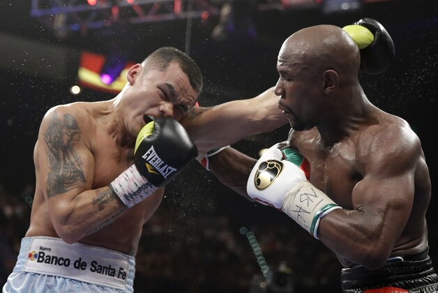 Marcos Maidana, left, from Argentina, trades blows with Floyd Mayweather Jr. in their WBC-WBA welterweight title boxing fight Saturday, May 3, 2014, in Las Vegas. Mayweather won the bout by majority decision. (AP Photo/Isaac Brekken)