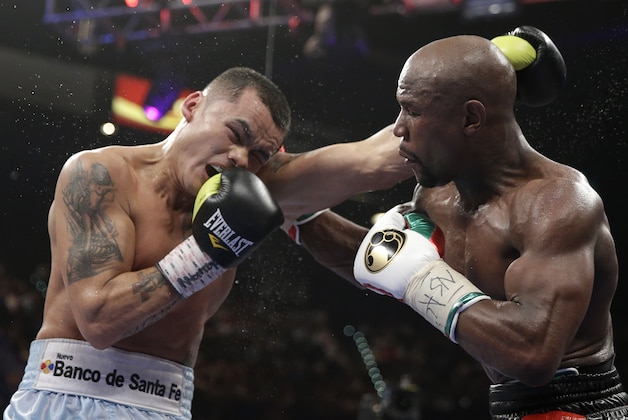 Marcos Maidana, left, from Argentina, trades blows with Floyd Mayweather Jr. in their WBC-WBA welterweight title boxing fight Saturday, May 3, 2014, in Las Vegas. Mayweather won the bout by majority decision. (AP Photo/Isaac Brekken)