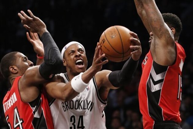 Toronto Raptors forward Patrick Patterson (54) and Raptors forward Amir Johnson (15) defend Brooklyn Nets forward Paul Pierce (34) as pierce goes up for a layup in the second half of Game 4 of an NBA basketball first-round playoff series at the Barclays Center, Sunday, April 27, 2014, in New York. The Raptors evened the series at 2-2 defeating the Nets 87-79. (AP Photo/Kathy Willens)