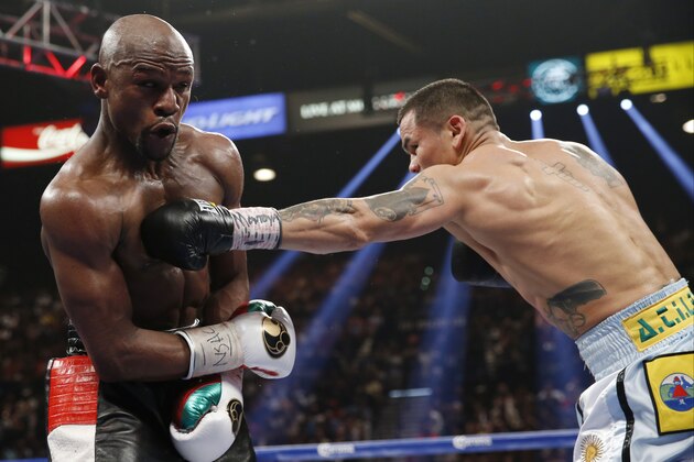 Marcos Maidana, right, from Argentina, throws a left to the body of Floyd Mayweather Jr. in their WBC-WBA welterweight title boxing fight Saturday, May 3, 2014, in Las Vegas. (AP Photo/Eric Jamison)