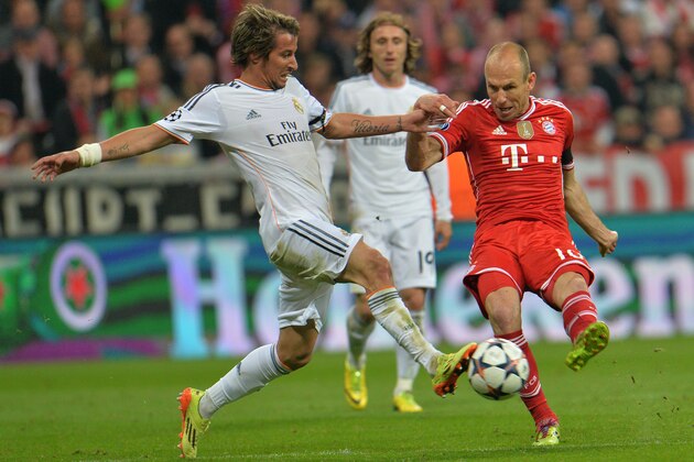 Real's Fabio Coentrao fights for the ball with Bayern's Arjen Robben during the Champions League semifinal second leg soccer match between Bayern Munich and Real Madrid at the Allianz Arena in Munich, southern Germany, Tuesday, April 29, 2014. (AP Photo/Kerstin Joensson)