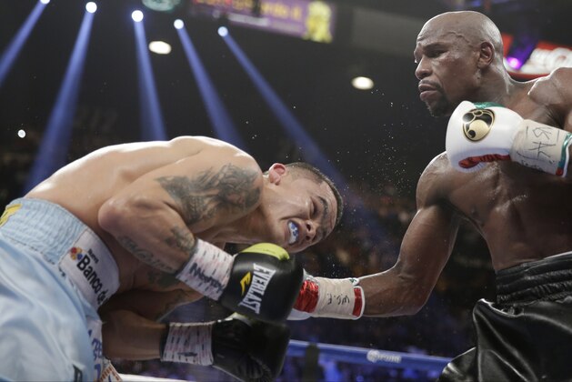 Floyd Mayweather Jr., right, connects with a right to the head of Marcos Maidana, from Argentina, in their WBC-WBA welterweight title boxing fight Saturday, May 3, 2014, in Las Vegas. (AP Photo/Isaac Brekken)