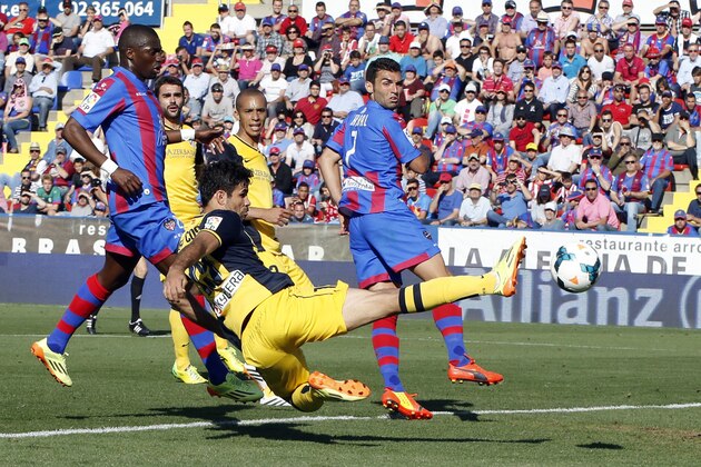 Atletico de Madrid's Diego Costa, front, shoots the ball as Levante's David Barral, right, and Simao, left, look on during a Spanish La Liga soccer match at the Ciutat de Valencia stadium in Valencia, Spain, on Sunday May 4, 2014. (AP Photo/Alberto Saiz)
