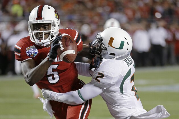 Miami defensive back Deon Bush (2) sacks Louisville quarterback Teddy Bridgewater (5) in the end zone for a safety during the first half of the Russell Athletic Bowl NCAA college football game in Orlando, Fla., Saturday, Dec. 28, 2013. (AP Photo/John Raoux)
