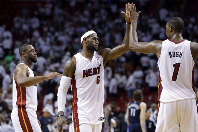 Miami Heat's LeBron James (6) high-fives Chris Bosh (1) after the Heat defeated the Charlotte Bobcats 101-97 in Game 2 of an opening-round NBA basketball playoff series, Wednesday, April 23, 2014, in Miami. At left is Dwyane Wade. (AP Photo/Lynne Sladky)