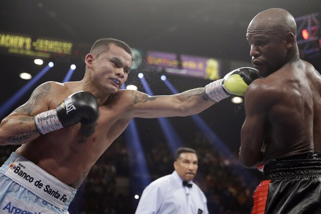 Marcos Maidana, left, from Argentina, throws a left at the head of Floyd Mayweather Jr. in their WBC-WBA welterweight title boxing fight Saturday, May 3, 2014, in Las Vegas. (AP Photo/Isaac Brekken)