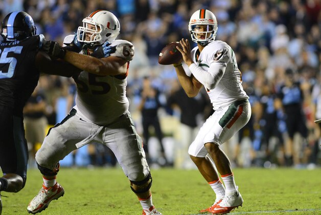 Oct 17, 2013; Chapel Hill, NC, USA; Miami Hurricanes quarterback Stephen Morris (17) looks to pass as offensive linesman Brandon Linder (65) and running back Dallas Crawford (25) block and North Carolina Tar Heels defensive end Kareem Martin (95) defends in the fourth quarter. The Miami Hurricanes defeated the North Carolina Tar Heels 27-23 at Kenan Memorial Stadium. Mandatory Credit: Bob Donnan-USA TODAY Sports