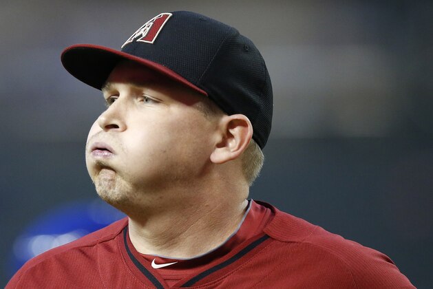 Arizona Diamondbacks' Trevor Cahill exhales as he walks off the field after giving up a run to the Chicago Cubs during the first inning of an exhibition baseball game, Friday, March 28, 2014, in Phoenix. (AP Photo/Ross D. Franklin)