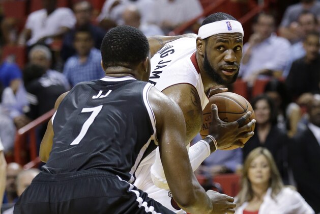 Miami Heat forward LeBron James, right, looks for an open teammate past Brooklyn Nets guard Joe Johnson (7) during the first half of an NBA basketball game, Wednesday, March 12, 2014, in Miami. (AP Photo/Wilfredo Lee)