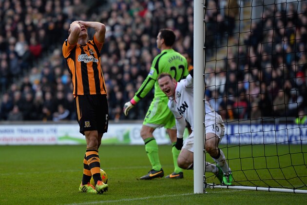 HULL, ENGLAND - DECEMBER 26:  James Chester of Hull scores an own goal in front of Wayne Rooney of Manchester United during the Barclays Premier League match between Hull City and Manchester United at KC Stadium on December 26, 2013 in Hull, England.  (Photo by Laurence Griffiths/Getty Images)