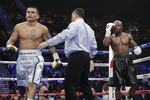 Marcos Maidana, left, is sent to his corner by referee Tony Weeks, center, after accidentally head butting Floyd Mayweather Jr. in their WBC-WBA welterweight title boxing fight Saturday, May 3, 2014, in Las Vegas. (AP Photo/Isaac Brekken)