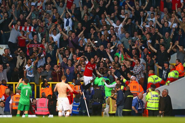 LONDON, ENGLAND - MARCH 16:  Lukas Podolski of Arsenal climbs into the away section to celebrate the 1-0 victory with the Arsenal fans during the Barclays Premier League match between Tottenham Hotspur and Arsenal at White Hart Lane on March 16, 2014 in London, England.  (Photo by Paul Gilham/Getty Images)