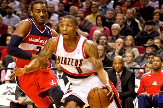 Jan 21, 2013; Portland, OR, USA; Portland Trail Blazers point guard Damian Lillard (0) drives past Washington Wizards point guard John Wall (2) at the Rose Garden. Mandatory Credit: Craig Mitchelldyer-USA TODAY Sports