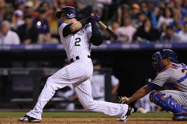 Colorado Rockies' Troy Tulowitzki, left, follows through with his swing after connecting for a single as New York Mets catcher Anthony Recker looks on in the seventh inning of the Rockies' 11-10 victory in a baseball game in Denver on Saturday, May 3, 2014. The hit was the 1,000th for Tulowitzki in his career. (AP Photo/David Zalubowski)