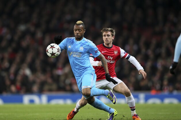 Marseille's Jordan Ayew, left, competes for the ball with Arsenal's Nacho Monorail during the Group F Champions League soccer match between Arsenal and Marseille at the Emirates stadium in London, Tuesday, Nov. 26, 2013. (AP Photo/Alastair Grant)