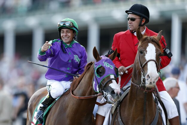 May 3, 2014; Louisville, KY, USA; Victor Espinoza gestures towards California Chrome after winning the 2014 Kentucky Derby at Churchill Downs. Mandatory Credit: Brian Spurlock-USA TODAY Sports