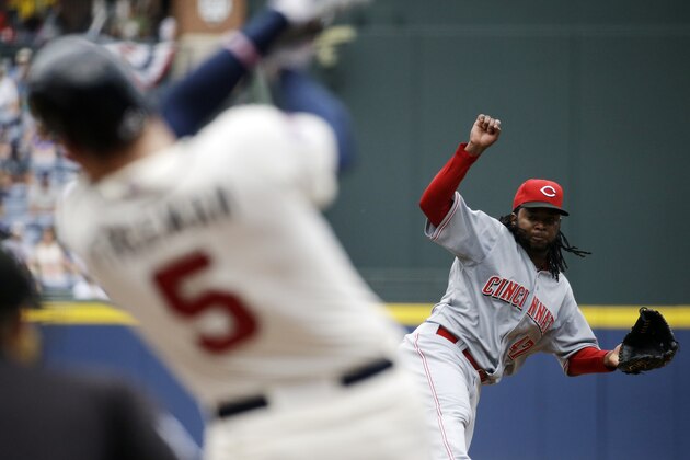 Cincinnati Reds starting pitcher Johnny Cueto, right, throws to Atlanta Braves' Freddie Freeman in the first inning of a baseball game, Sunday, April 27, 2014, in Atlanta. (AP Photo/David Goldman)