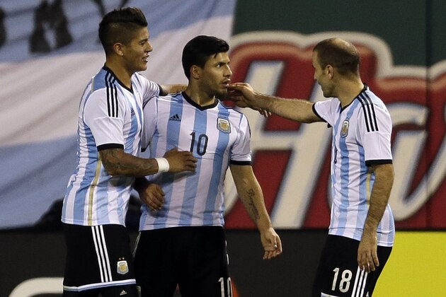 Argentina's Sergio Aguero, center, is congratulated by teammates Marcos Rojo, left, and Rodrigo Palacio after scoring during the second half of an international friendly soccer match against Bosnia Monday, Nov. 18, 2013, in St. Louis. Argentina won 2-0. (AP Photo/Jeff Roberson)